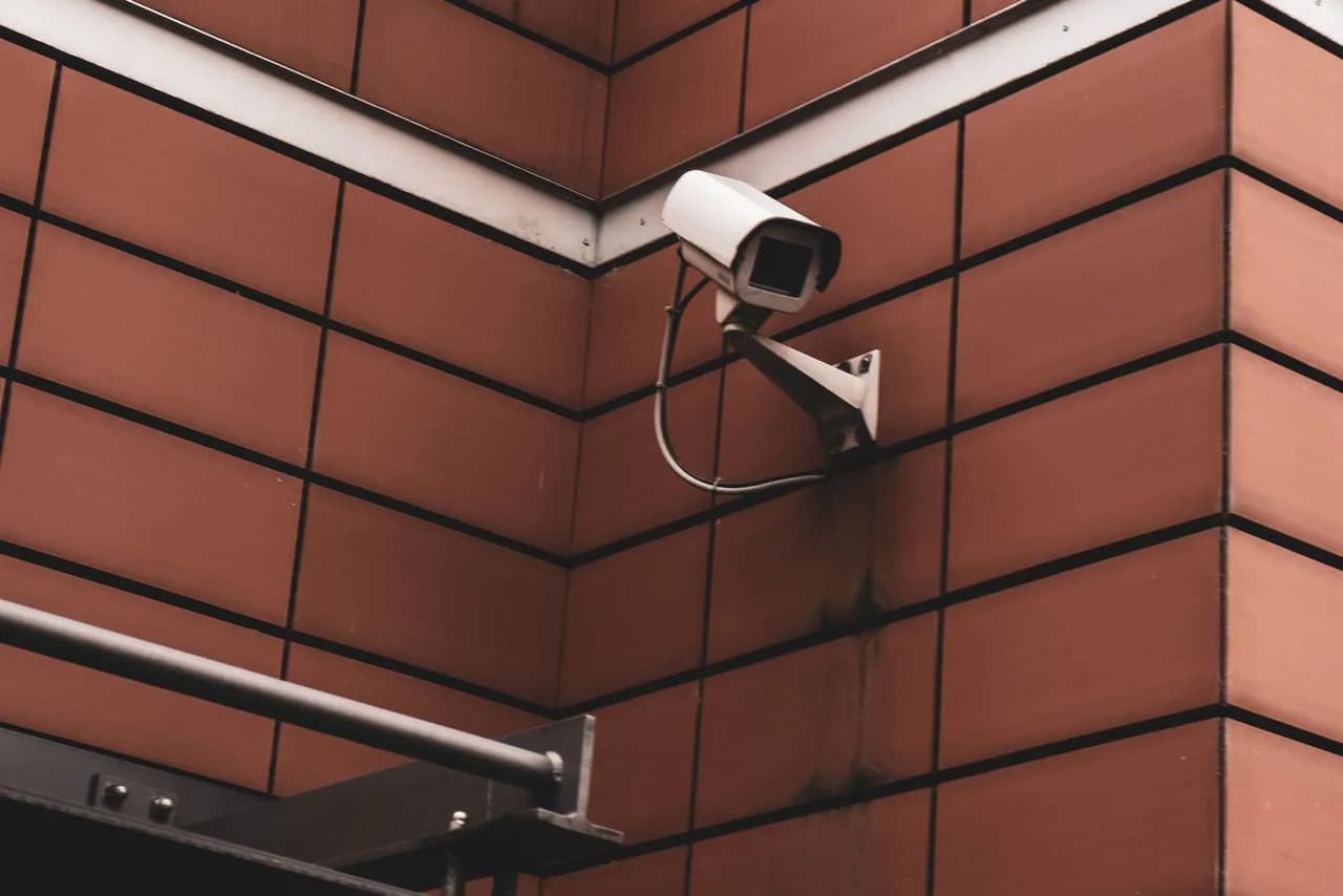 White CCTV security camera mounted on a building